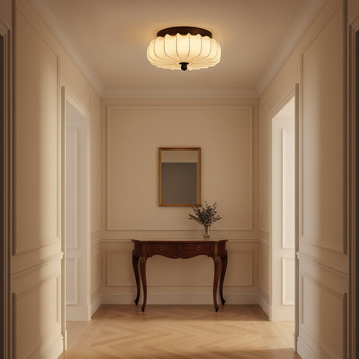 A pleated fabric Clérachic ceiling light lit above a panelled hallway, with a carved wooden console and a small mirror.