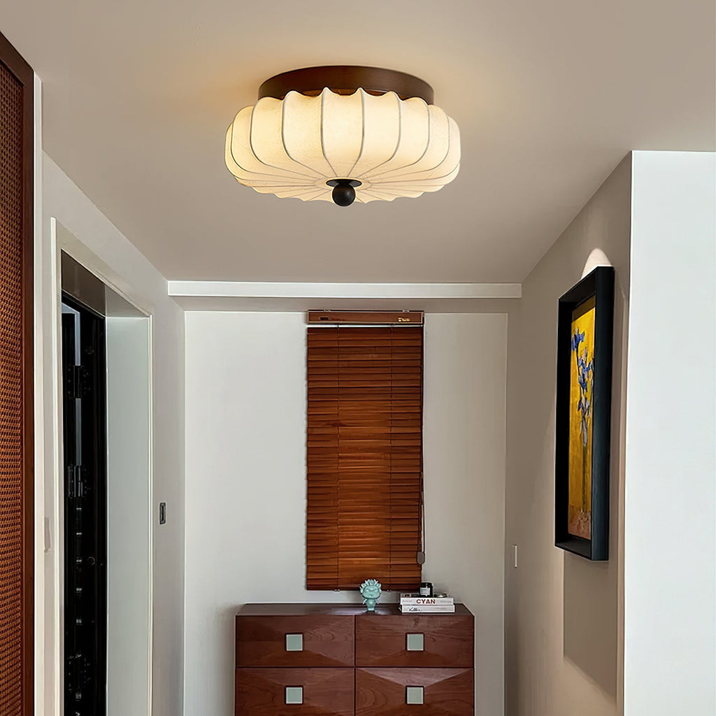 Large in the frame, this pleated fabric Clérachic ceiling light hangs above a hallway with a walnut chest of drawers.