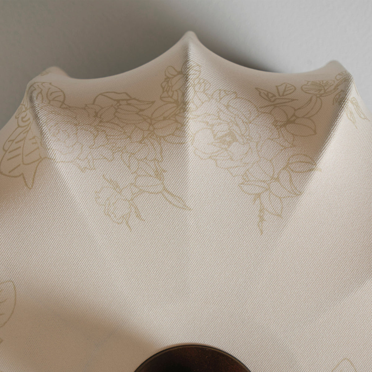 Close view of the folded edge and floral print on the fabric shade of this Clérachic ceiling light.
