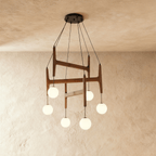 Clérachic's chandelier in dark red mahogany wood, six frosted glass globes suspended from its layered frame.