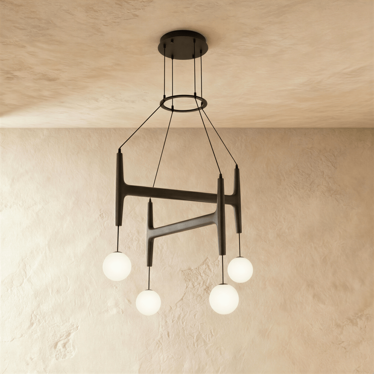 Clérachic's chandelier in black walnut wood, four frosted glass globes hanging from its branching frame.