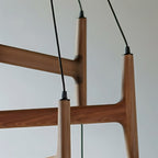 A close detail of the Clérachic chandelier's mahogany wood joinery, showing its branching frame construction.