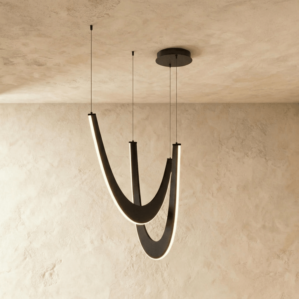 Clérachic chandelier of three boomerang-shaped oak loops in black wood, edge-lit in warm white on fine suspension wires.