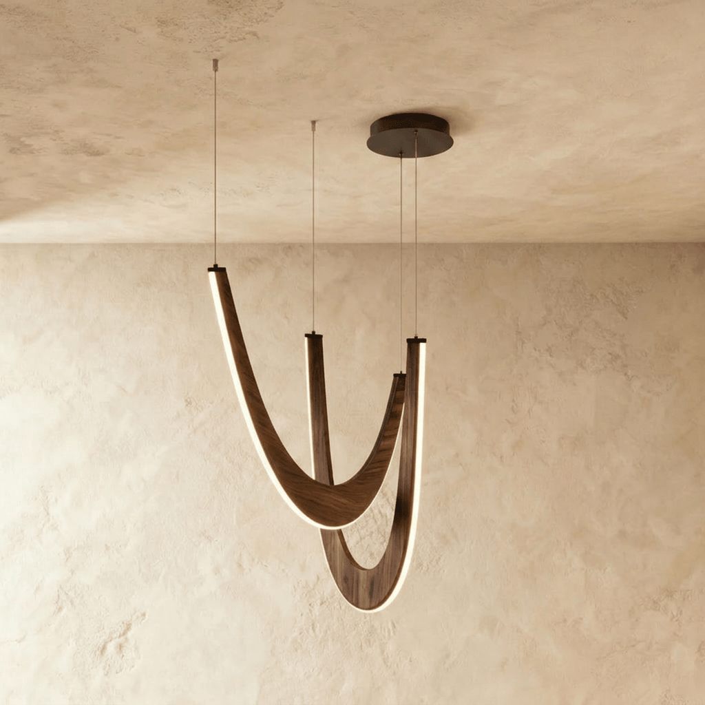 Clérachic chandelier of three boomerang-shaped oak loops in dark wood, edge-lit and hanging from a black round canopy.