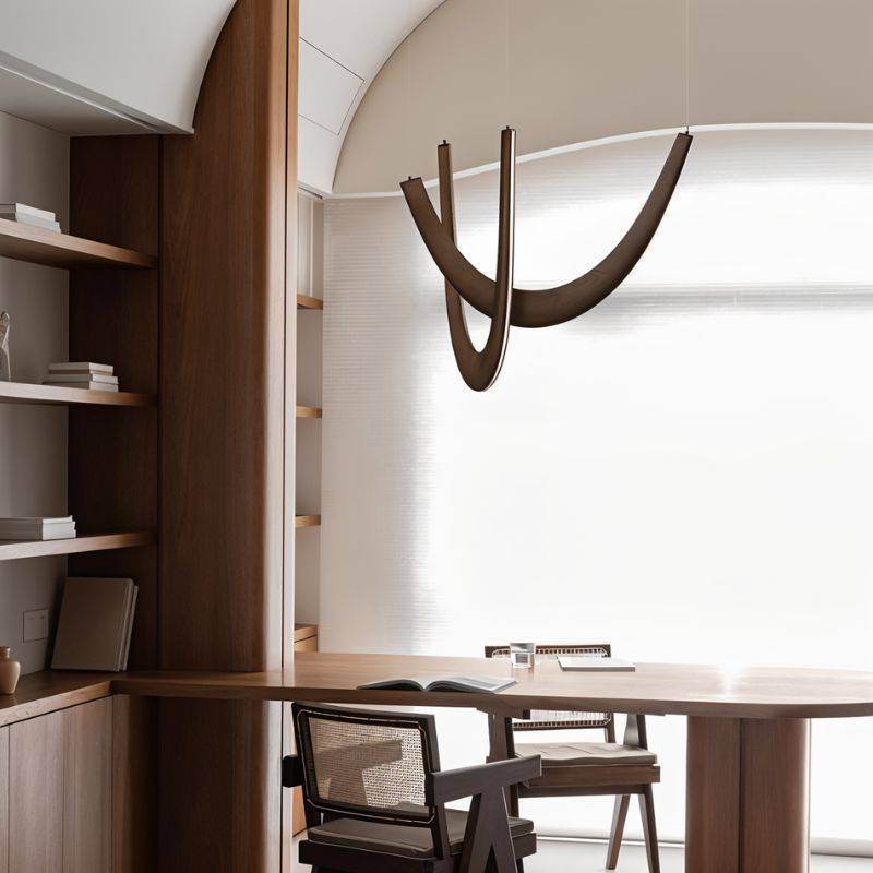 Clérachic dark wood chandelier of curved oak loops hanging above a walnut desk and rattan chairs by a large window.