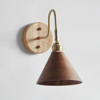Close view of the light wood backplate, brass gooseneck and walnut-colour cone shade of this Clérachic wall light.