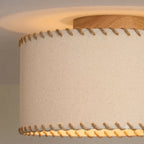 Close view of the rope stitching along the hem and the oak-toned canopy on this Clérachic ceiling light, with warm light glowing beneath the shade.