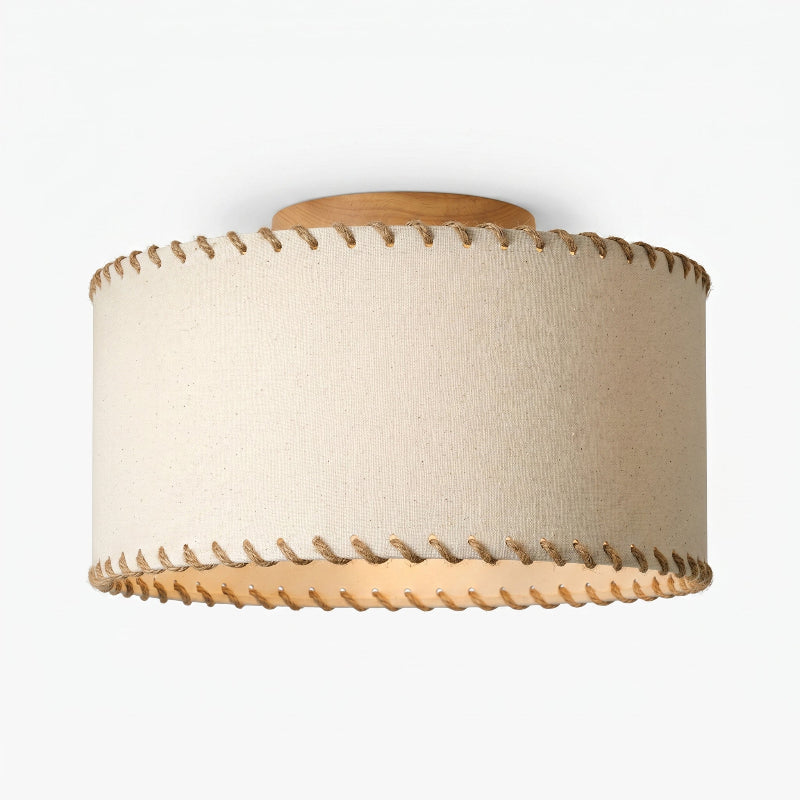 Angled view from below of a Clérachic linen drum ceiling light, its rope-trimmed rim and wood canopy against a pale backdrop.