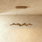 Clérachic wavy wood-finish chandelier on two cables, shown lit with a cool white LED line along its curved underside.