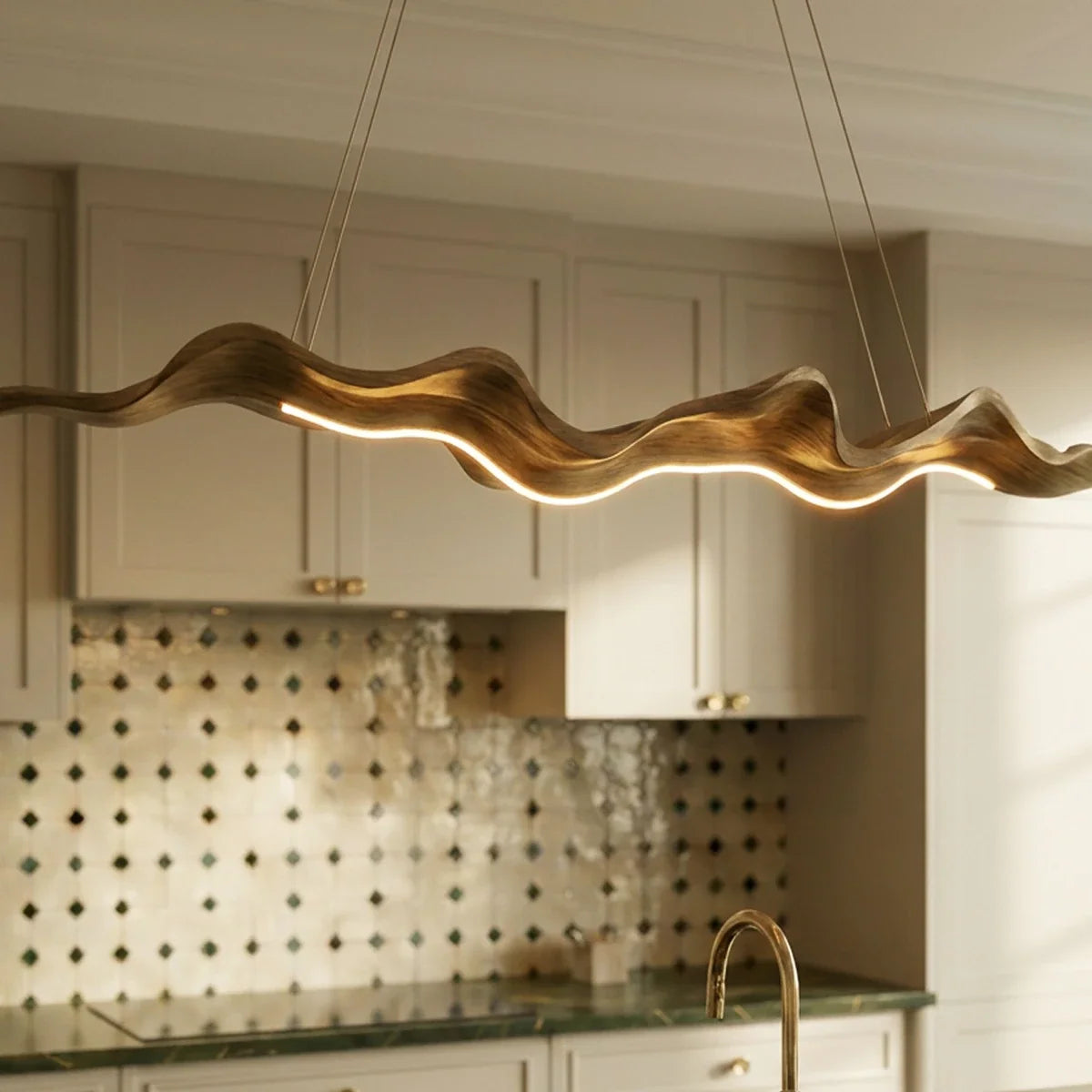 Clérachic wavy wood-finish chandelier in close-up, its warm LED line tracing the curves above a patterned tile kitchen splashback.