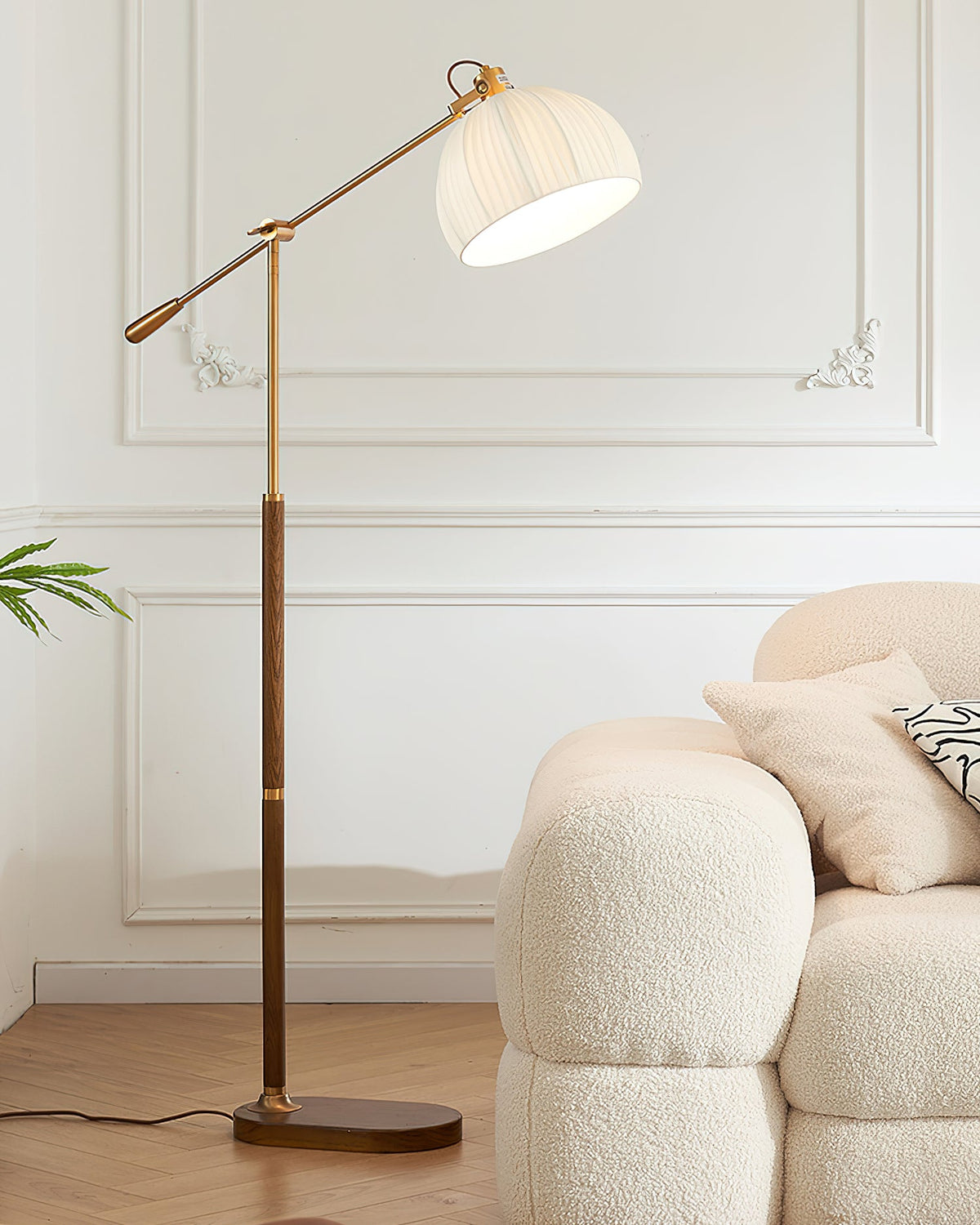 Full-height view of this Clérachic floor lamp in a white panelled room, the oval base on a wood floor beside a cream armchair.