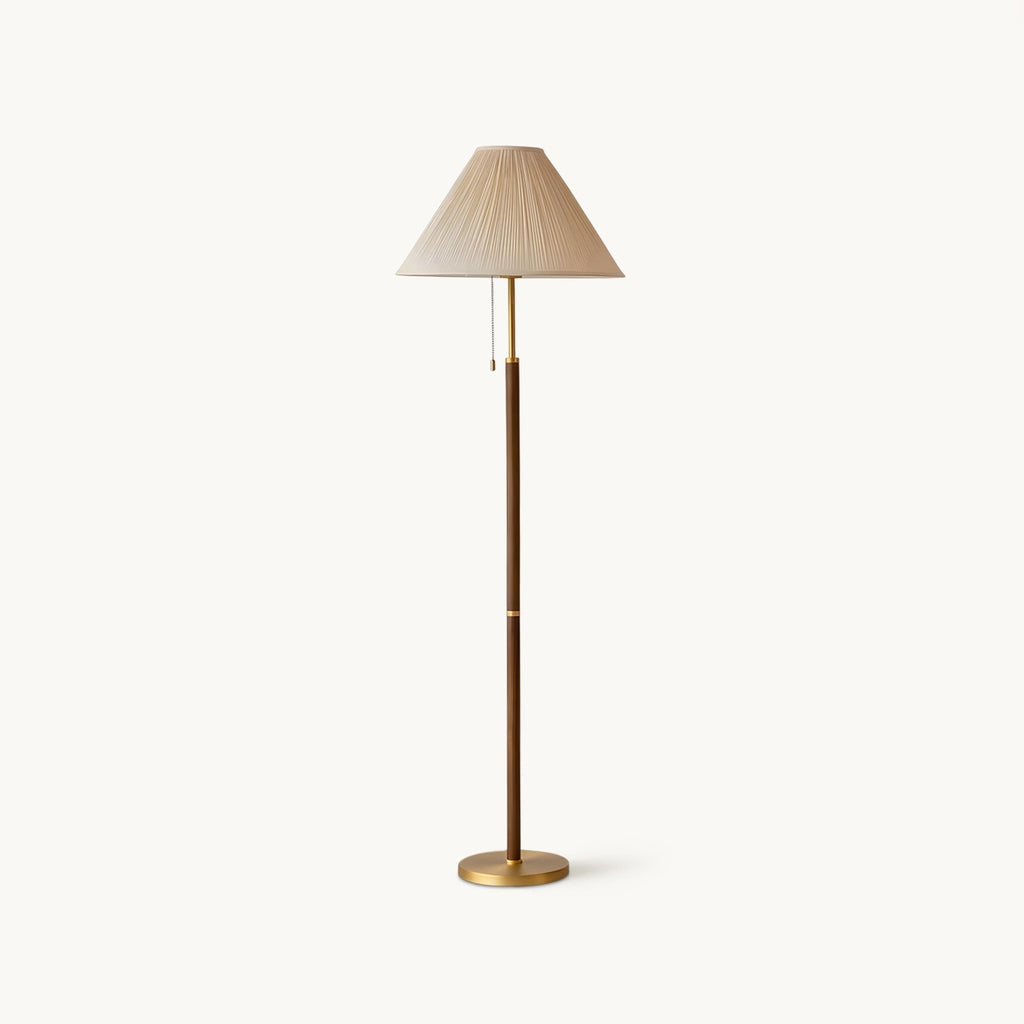 Front view of this Clérachic floor lamp on a plain off-white backdrop, with a pleated beige conical shade, walnut-toned stem and round brass base.