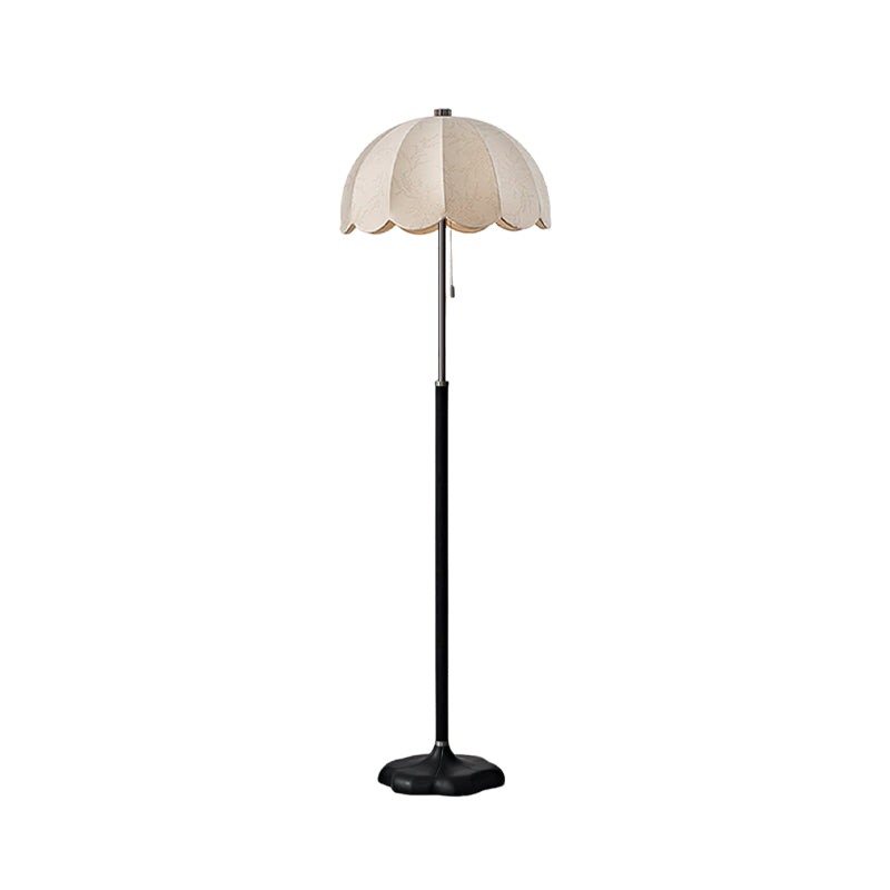 Clérachic floor lamp in a black-stemmed version with a white scalloped shade and black base, on a white backdrop.