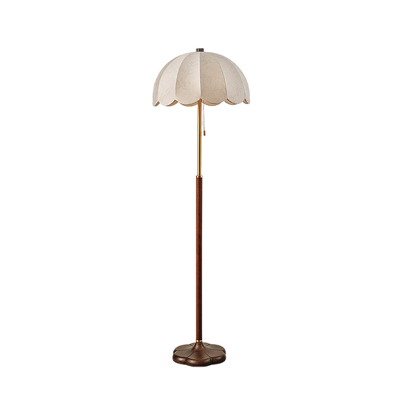 Cut-out view of this Clérachic floor lamp with a walnut-toned stem, brass neck and white scalloped shade, on a white backdrop.