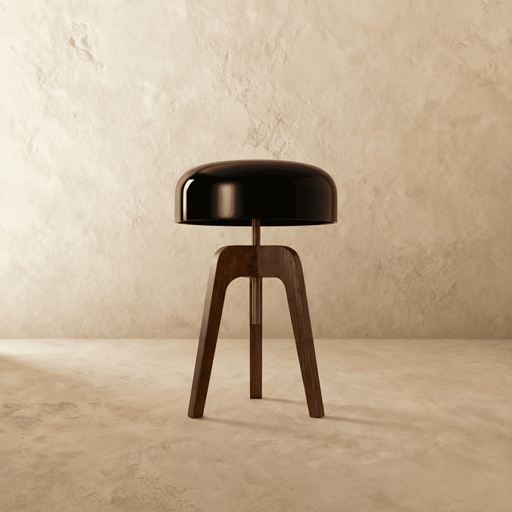Clérachic compact dark wood tripod lamp with a glossy black disc shade, switched off, against a limewash wall.