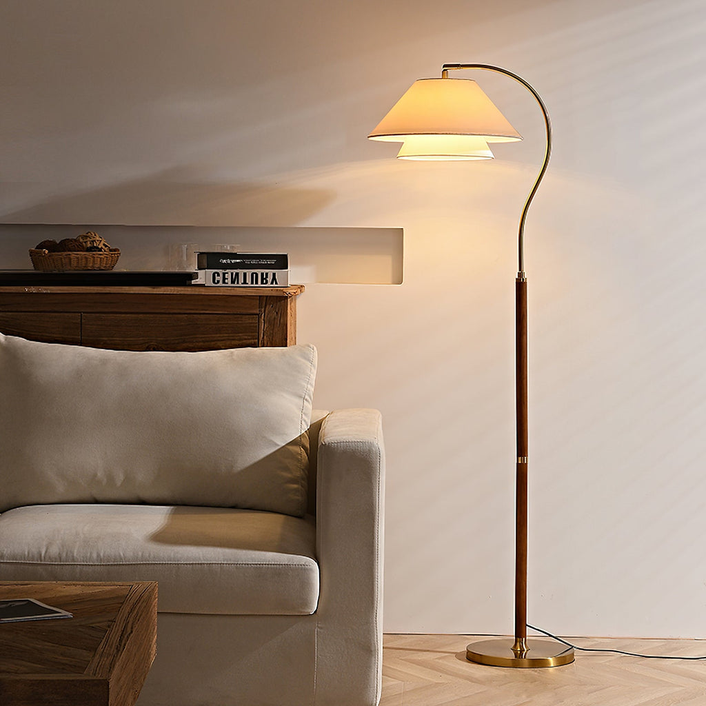 Evening glow from this Clérachic floor lamp, whose layered shade lights a cream wall above a pale armchair.