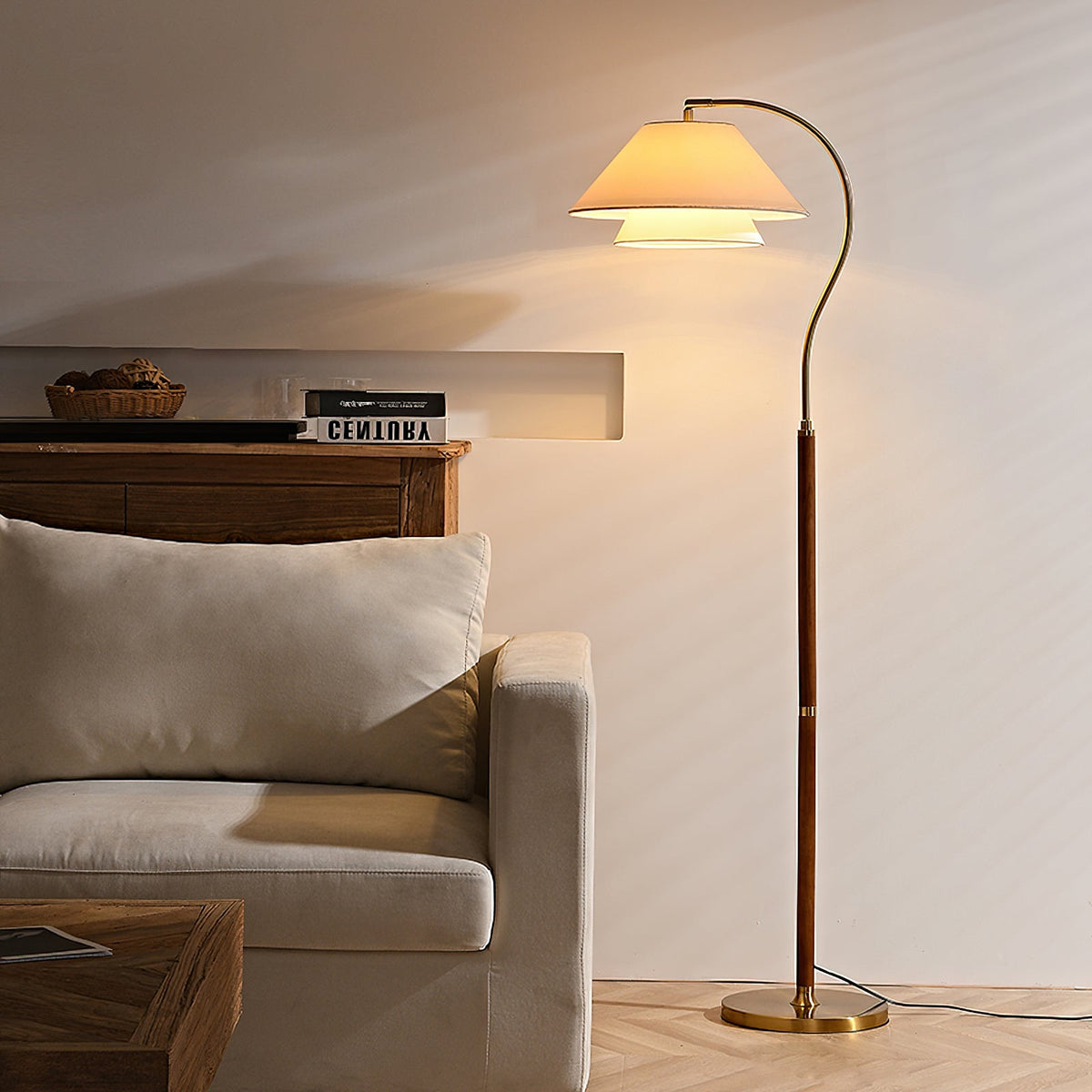 Evening glow from this Clérachic floor lamp, whose layered shade lights a cream wall above a pale armchair.