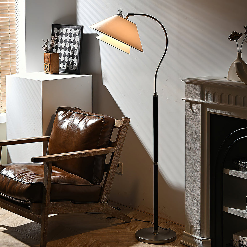 Late sunlight crosses the shade of this Clérachic floor lamp, beside a leather lounge chair and a white fireplace.