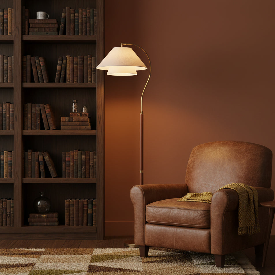 The Clérachic floor lamp stands against a terracotta wall by a tall bookcase, next to a brown leather armchair.