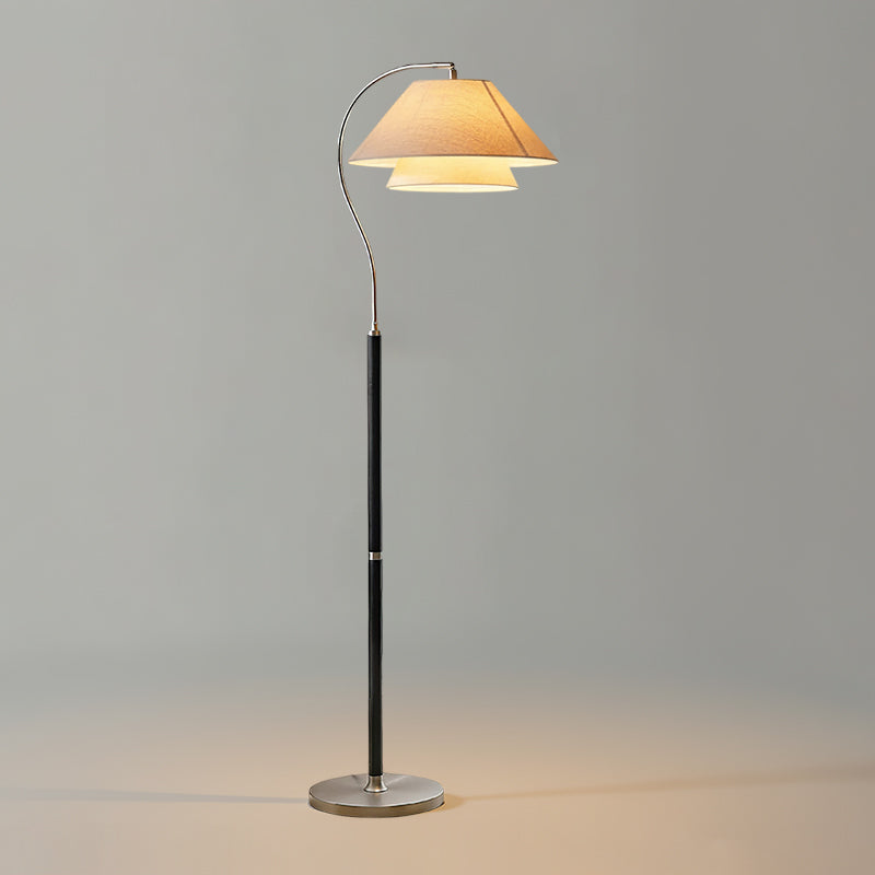 A black-stemmed Clérachic floor lamp with a pale shade and a silver base, lit against a plain grey backdrop.