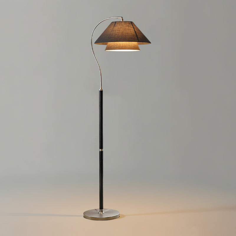 Black-stemmed Clérachic floor lamp with a charcoal shade and a silver base, glowing on a plain grey backdrop.
