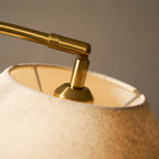 Close view of the brass joint and bulb holder inside the linen shade of this Clérachic floor lamp.