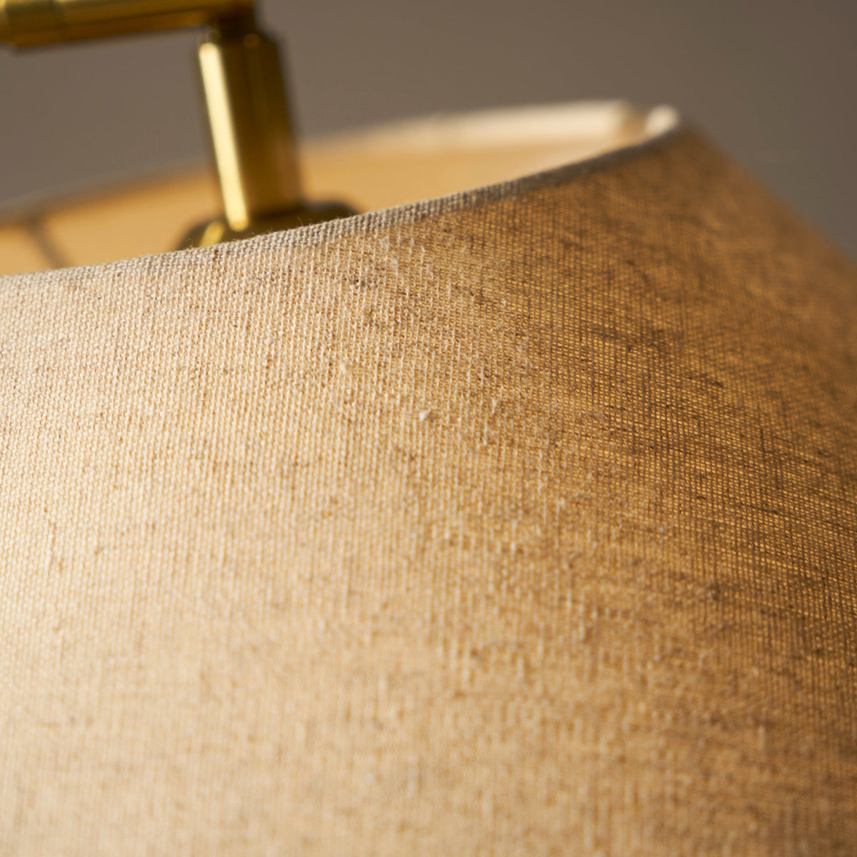 Close view of the woven linen texture on the shade of this Clérachic floor lamp, with the brass fitting above.