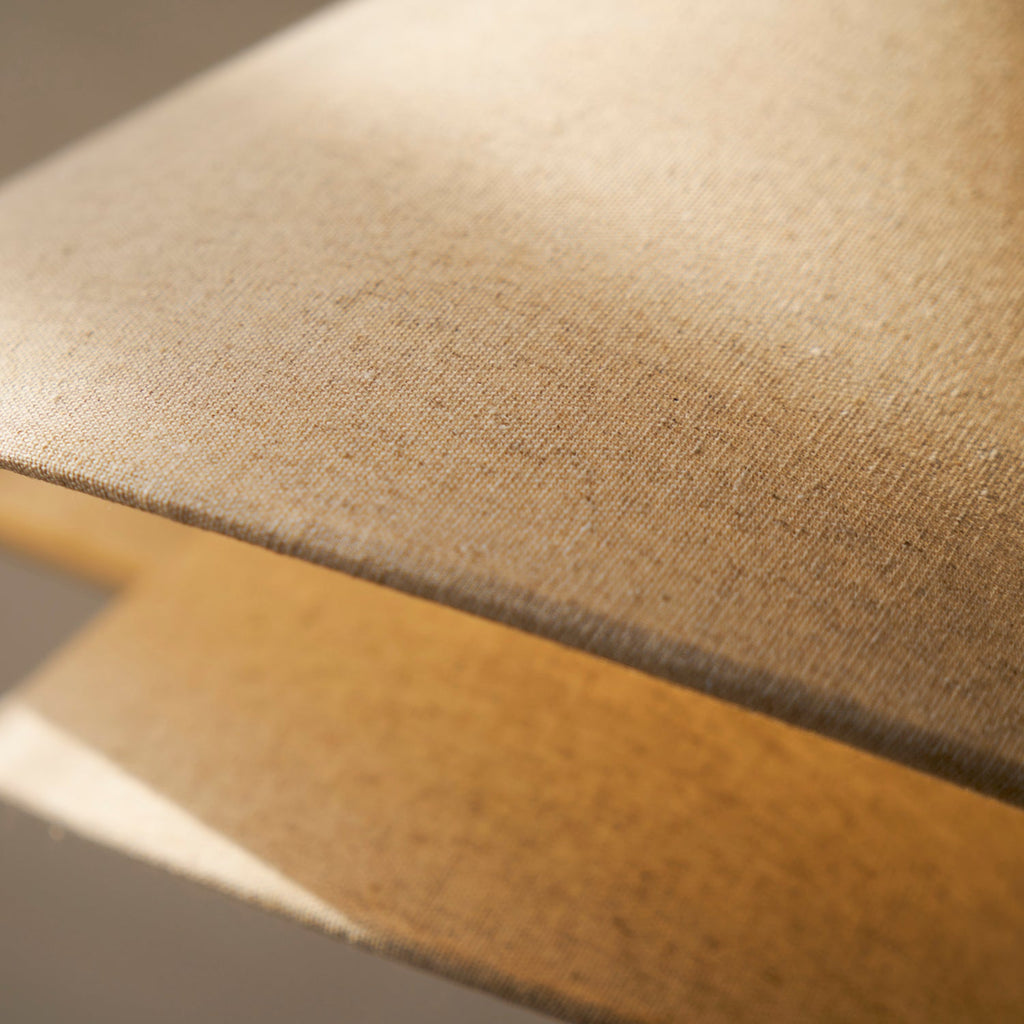 Underside of the lit linen shade on this Clérachic floor lamp, showing the soft glow inside the upper tier.
