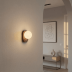 Clérachic wall lamp glowing in a hallway archway, with a console table visible through the opening.