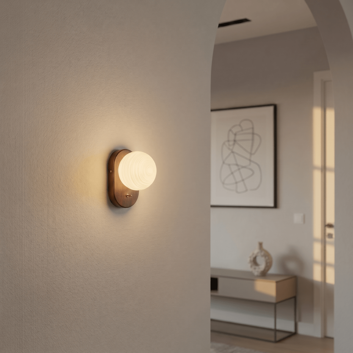Clérachic wall lamp glowing in a hallway archway, with a console table visible through the opening.