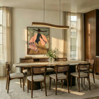 A Clérachic wood-grain bar pendant hangs above a long dining table set beneath a large framed painting.
