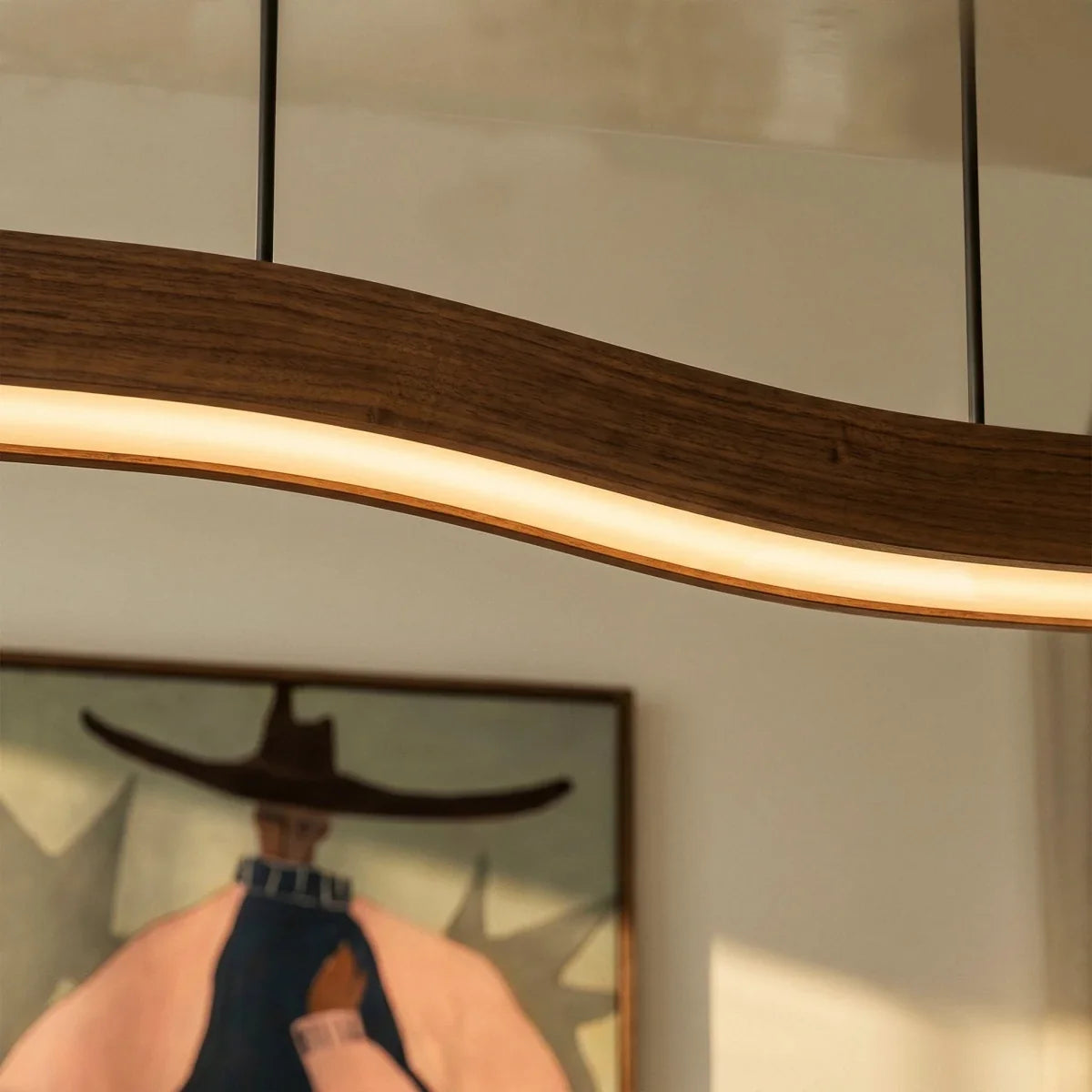 Close-up on the Clérachic pendant's curved walnut body reveals its grain and the warm light strip along one edge.
