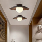 Two Clérachic ceiling lights of different sizes, with walnut-toned shades and frosted globes, in a corridor beside wooden shelving.