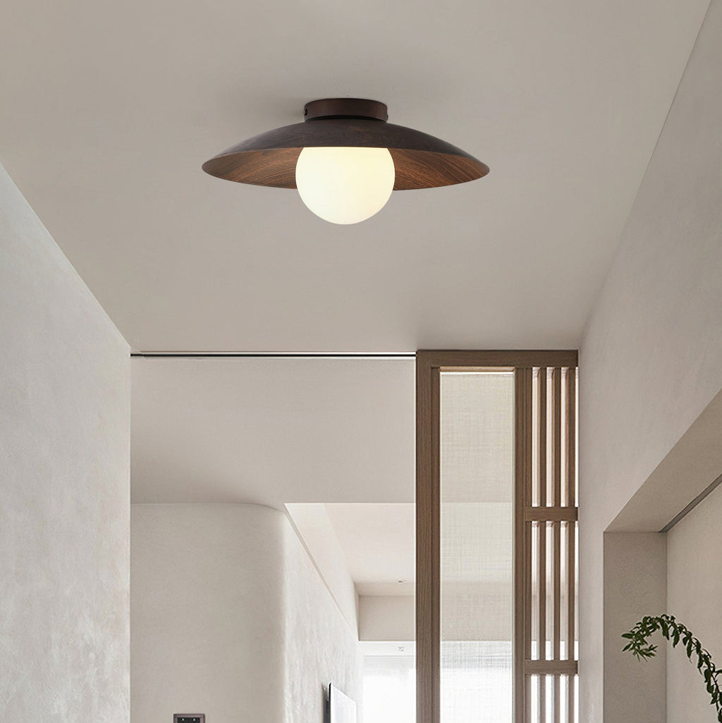 A Clérachic flush-mount ceiling light with a walnut-toned shade and a white glass globe, above a hallway with a slatted wood screen.