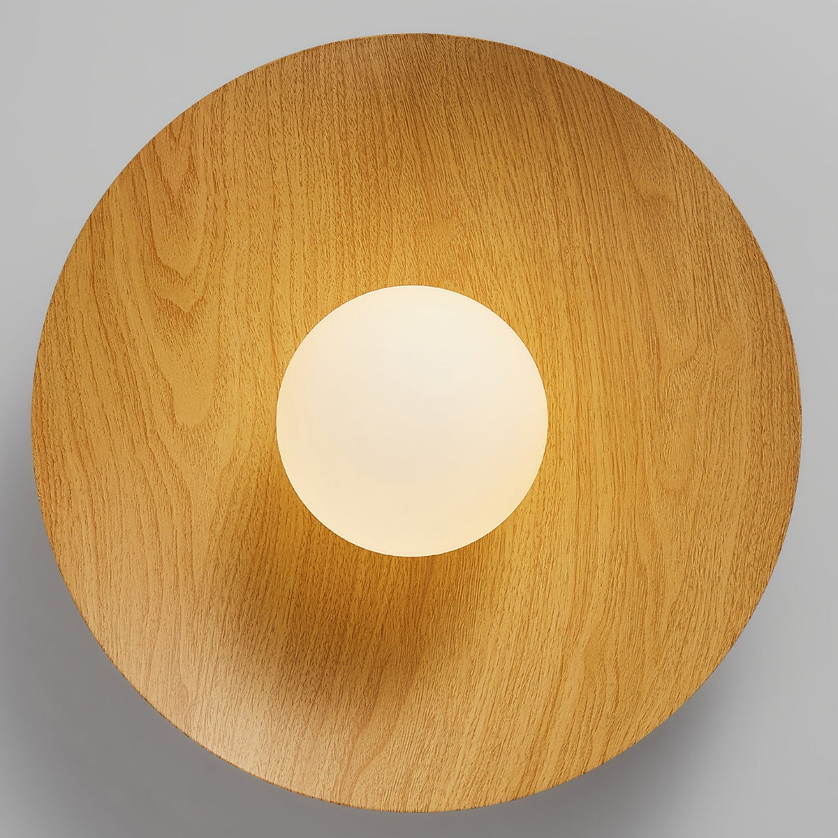 Looking straight up at the underside of this Clérachic ceiling light, a natural wood-grain disc frames the frosted white globe.