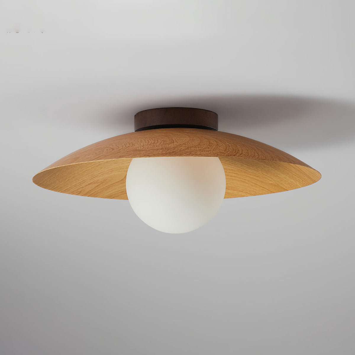 Side view of this Clérachic natural wood-grain ceiling light, with a dark round ceiling plate and a frosted white glass globe.