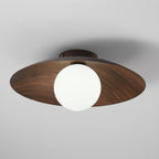 Looking up from below, this Clérachic ceiling light shows its walnut wood-grain underside and a large frosted white globe.