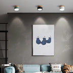 Green, black and white Clérachic Wood-Grain Cylinder Ceiling Lights in a row, scalloping a grey living room wall.