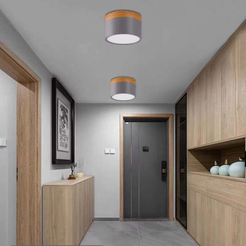 Two grey Clérachic Wood-Grain Cylinder Ceiling Lights lighting an oak-panelled entrance hall by the front door.