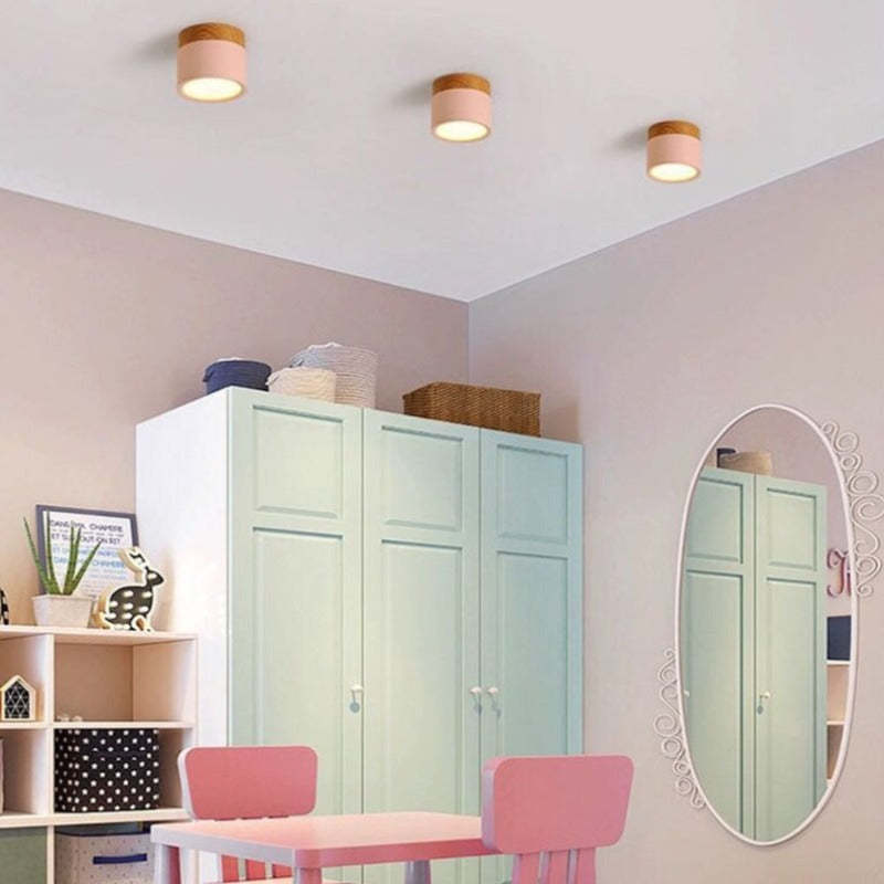 Three pink Clérachic Wood-Grain Cylinder Ceiling Lights lit in a child's room above a mint green wardrobe.