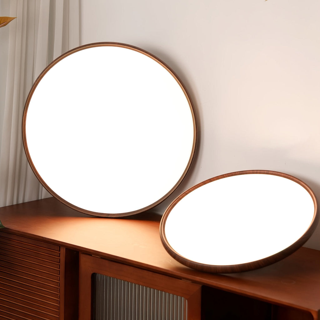 Two of this Clérachic ceiling light's round fittings on a dark wood sideboard, one upright and one tilted, with white diffusers showing.
