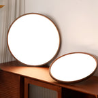 Two of this Clérachic ceiling light's round fittings on a dark wood sideboard, one upright and one tilted, with white diffusers showing.