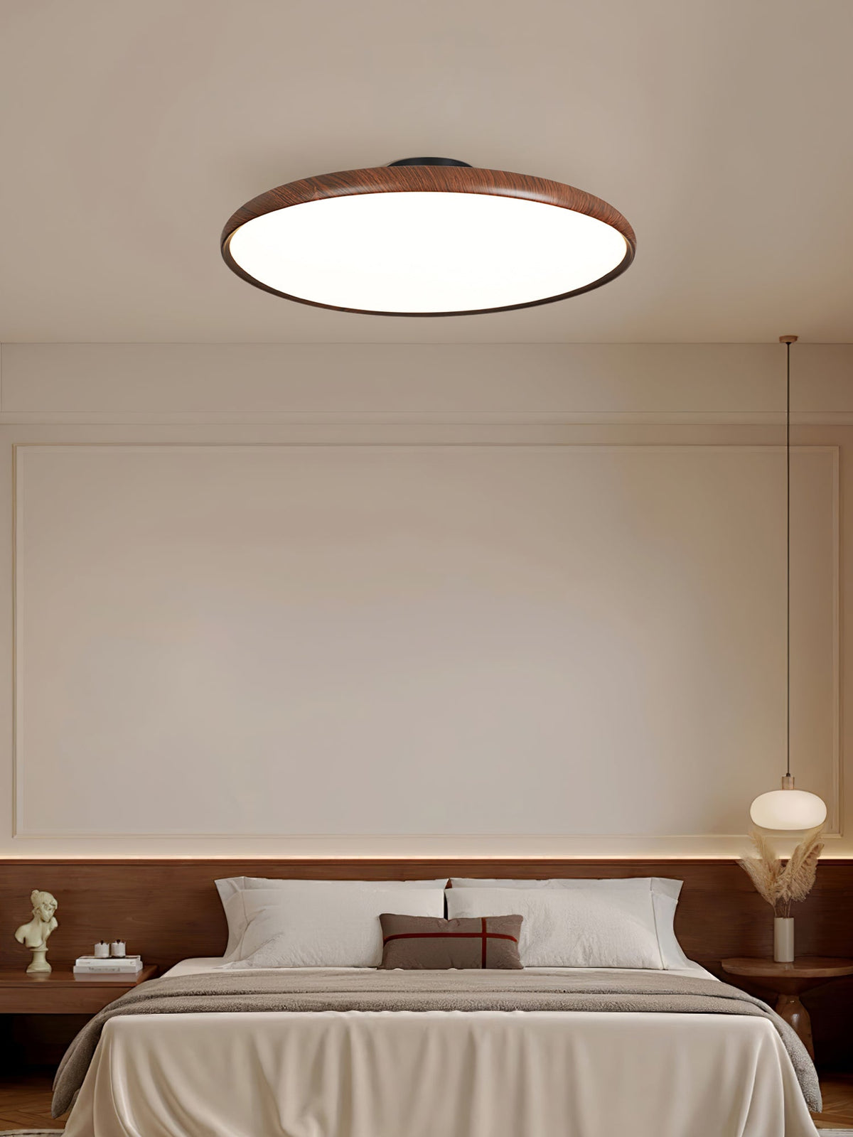 Walnut-grain Clérachic ceiling light above a bed with a dark wood headboard and a pendant lamp beside it.