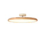 Lit light wood-grain Clérachic ceiling light with a cream canopy, glowing warm white on a white backdrop.