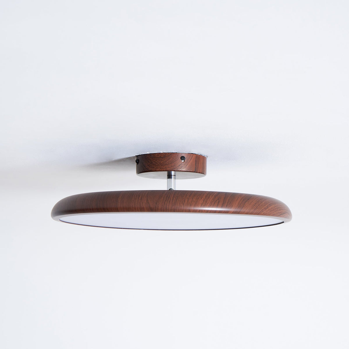 A walnut-grain Clérachic ceiling light with a matching wood-effect canopy and a pale diffuser, against a white ceiling.