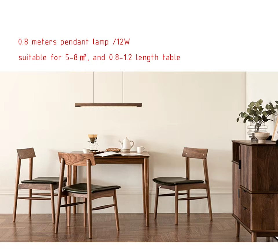 The 80 cm Clérachic walnut beam pendant hanging over a small dining table, sized for tables of 0.8 to 1.2 m.