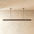 Clérachic's black walnut wood pendant bar hangs level from two thin cables against a plaster wall.