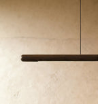 This close view of the Clérachic black walnut pendant bar shows its rounded end and slim LED light strip.