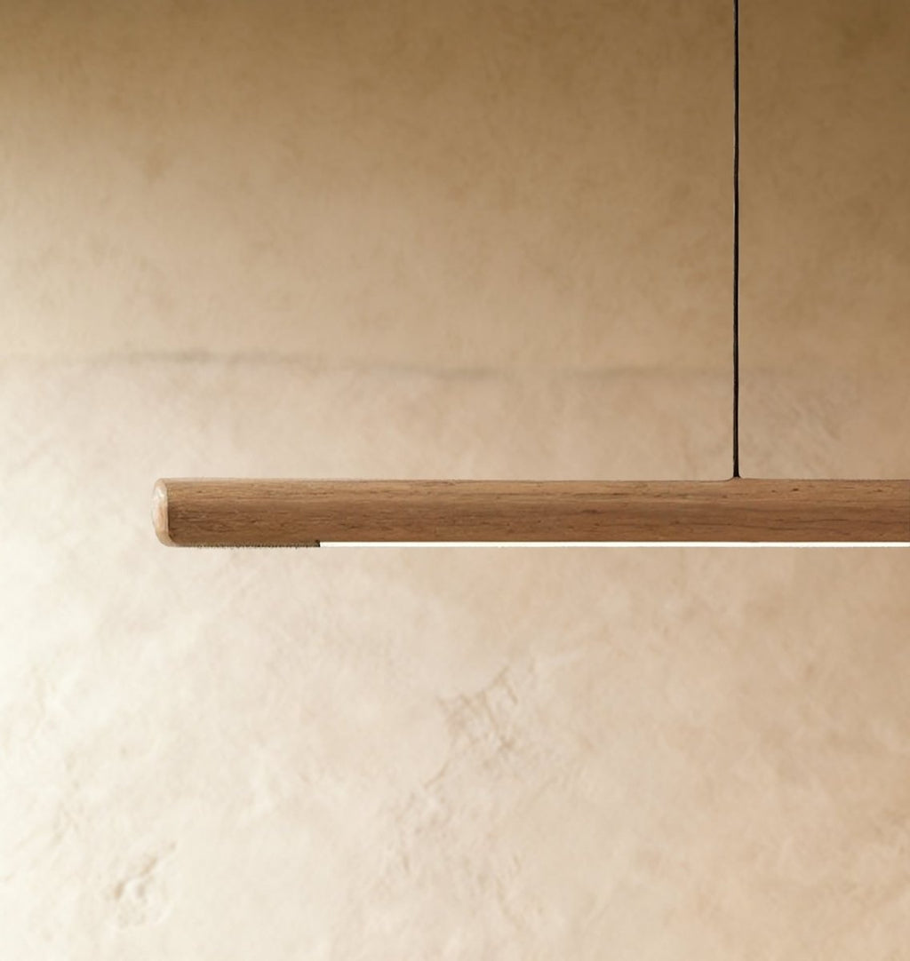 This close crop of the Clérachic black walnut pendant bar highlights its rounded end and warm LED glow.