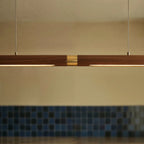 A close view shows the brass center joint on the long Clérachic black walnut pendant bar's wood run.